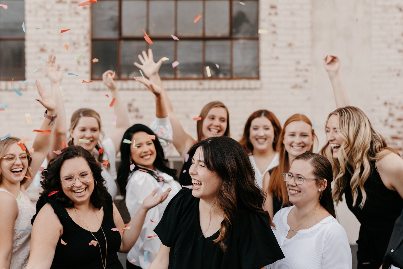 wichita small business mentor consultant smiles with group of women behind her throwing confetti